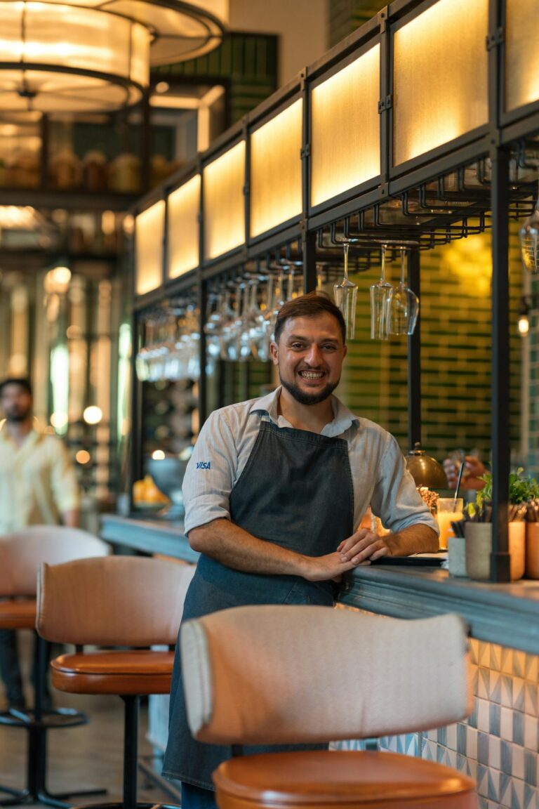Smiling Waiter Standing behind Chair
